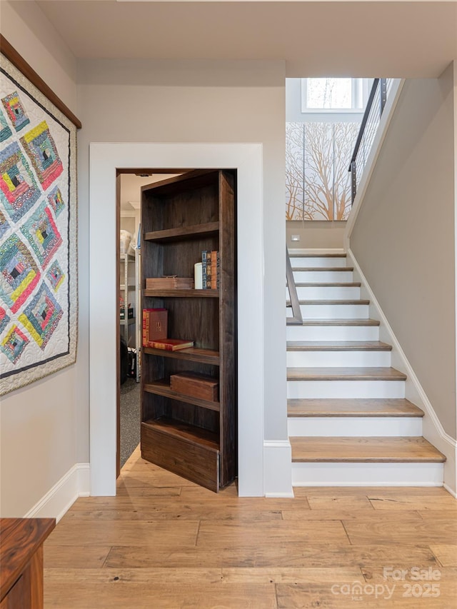 stairway featuring baseboards and wood finished floors