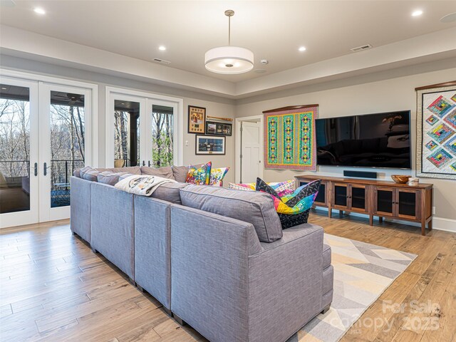 living room with light wood finished floors, visible vents, recessed lighting, and french doors