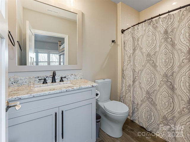 full bathroom featuring visible vents, toilet, curtained shower, wood finished floors, and vanity