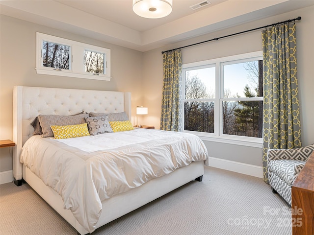 bedroom featuring multiple windows, baseboards, visible vents, and light carpet