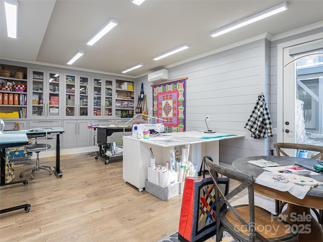 office area featuring light wood-type flooring and a wall mounted air conditioner