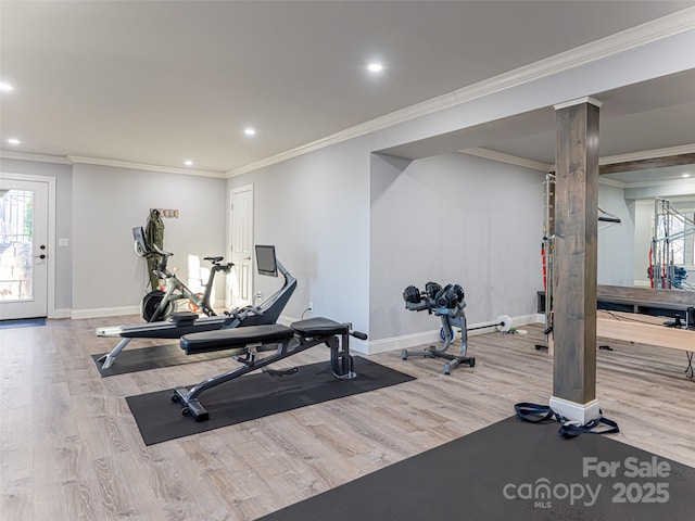 exercise area featuring a wealth of natural light, ornamental molding, and wood finished floors