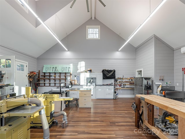 home office featuring beam ceiling, a workshop area, high vaulted ceiling, a ceiling fan, and dark wood-style flooring