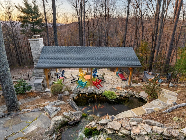 exterior space featuring a small pond, an outdoor structure, and fence