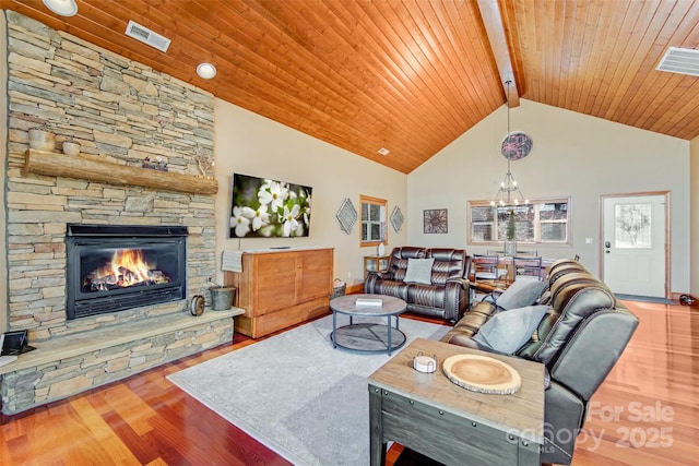 living room featuring wood finished floors, visible vents, high vaulted ceiling, a fireplace, and wood ceiling