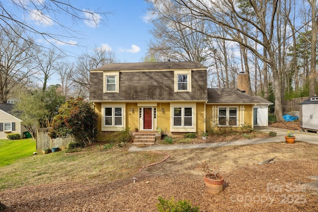 dutch colonial featuring fence, roof with shingles, a gambrel roof, a chimney, and a front lawn