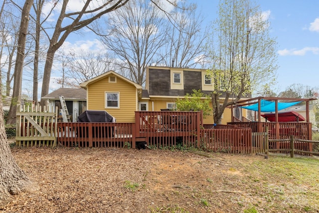 back of property with a wooden deck, a gambrel roof, and a shingled roof