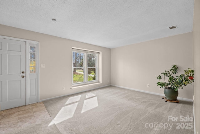 interior space with baseboards, visible vents, and a textured ceiling