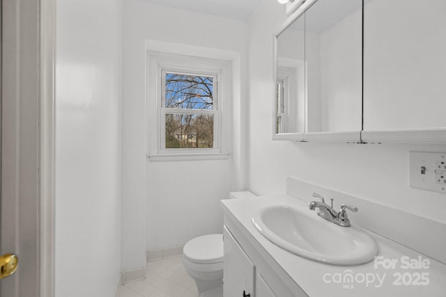 bathroom with vanity, toilet, baseboards, and tile patterned flooring