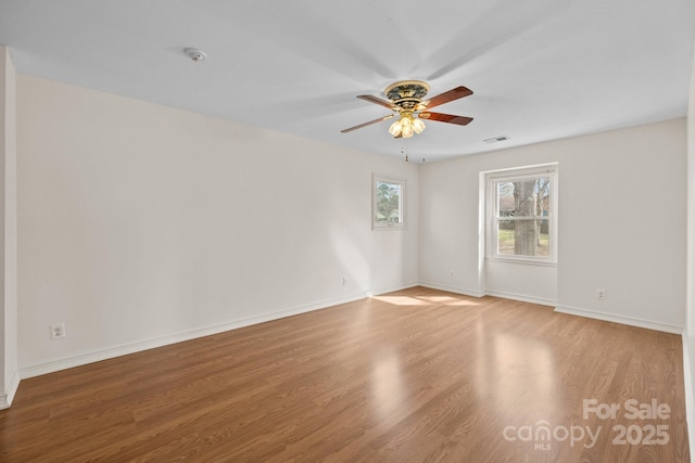 unfurnished room featuring visible vents, baseboards, ceiling fan, and wood finished floors