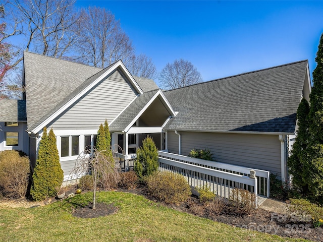 view of front facade featuring a front yard and roof with shingles