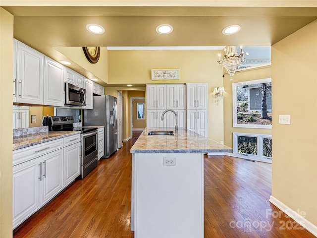 kitchen with appliances with stainless steel finishes, dark wood-style floors, a notable chandelier, white cabinetry, and a sink