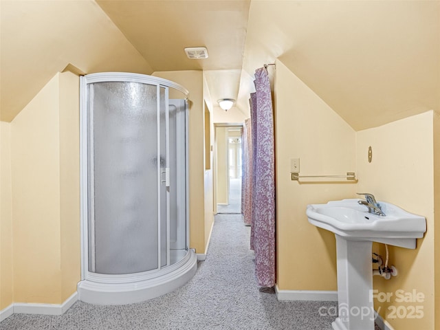 full bathroom featuring baseboards, lofted ceiling, and a shower stall