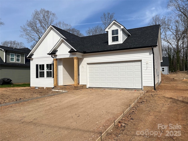 view of front of home with a garage, dirt driveway, and a shingled roof