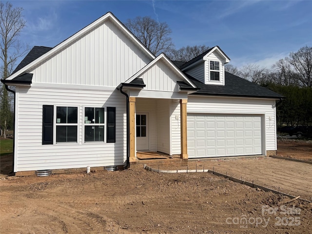 view of front of property featuring a garage, board and batten siding, and dirt driveway