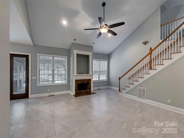 unfurnished living room featuring stairway, baseboards, visible vents, and ceiling fan