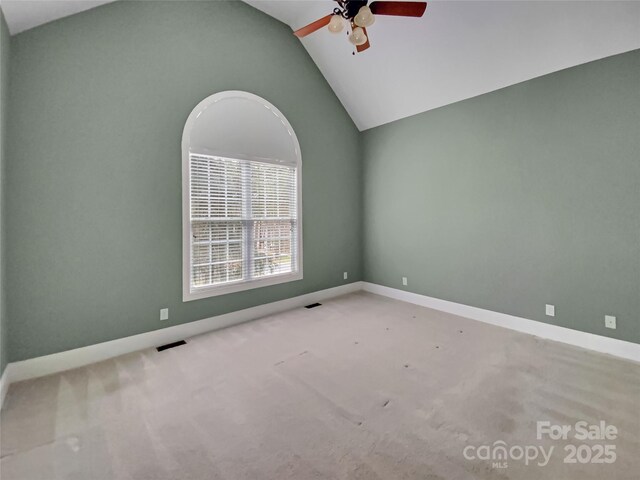 spare room featuring visible vents, baseboards, carpet flooring, lofted ceiling, and ceiling fan