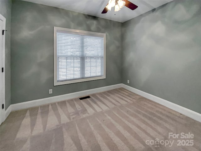 unfurnished room with visible vents, baseboards, ceiling fan, and carpet flooring