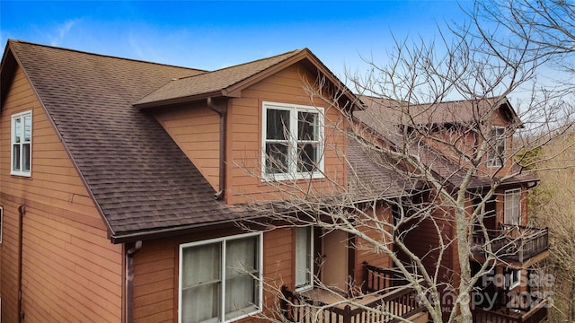 view of property exterior with a shingled roof