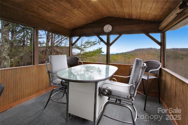 sunroom / solarium with wooden ceiling, a healthy amount of sunlight, and vaulted ceiling