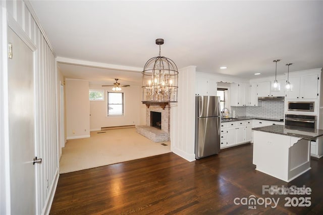 kitchen with a ceiling fan, dark countertops, open floor plan, white cabinetry, and stainless steel appliances