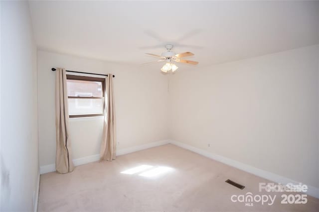 carpeted empty room with visible vents, baseboards, and ceiling fan