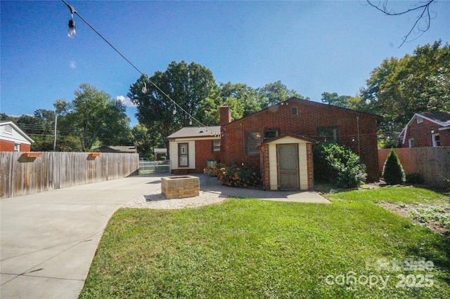 view of front facade featuring a front yard, fence, brick siding, and a chimney