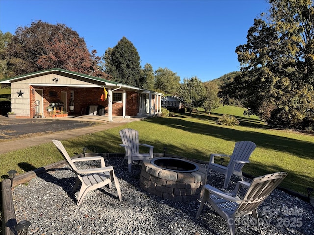 view of yard featuring a fire pit and a patio