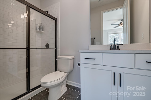 bathroom with toilet, a stall shower, a ceiling fan, baseboards, and vanity