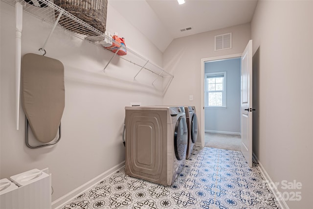 laundry area featuring visible vents, baseboards, and washing machine and clothes dryer