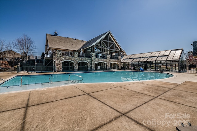 community pool featuring a patio area and fence