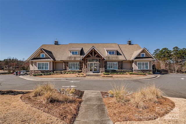 craftsman inspired home featuring stone siding and french doors