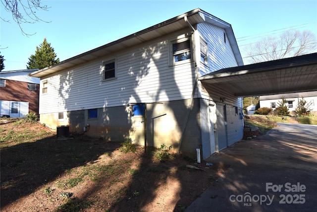 view of side of property with a carport and central air condition unit