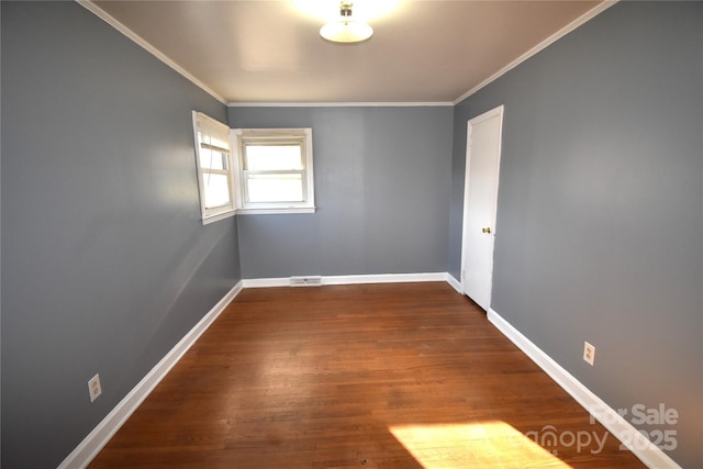 unfurnished room featuring dark wood-type flooring, crown molding, baseboards, and visible vents