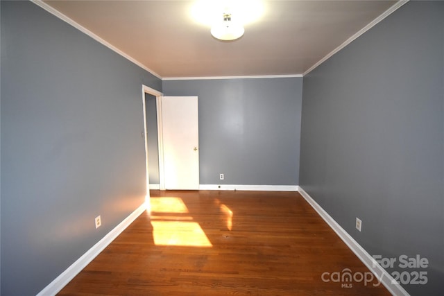 spare room with wood finished floors, baseboards, and ornamental molding