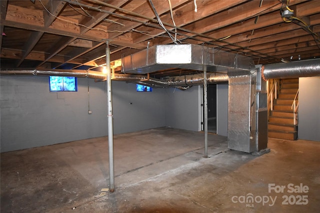 basement featuring stairs and heating unit