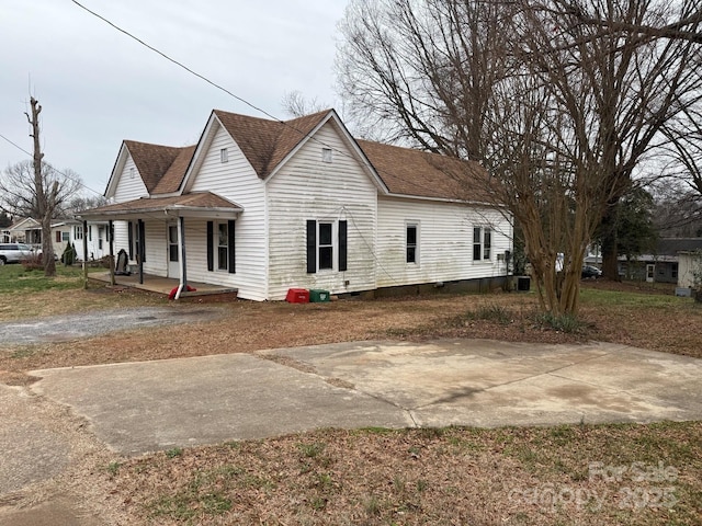 view of front of house with crawl space, covered porch, and a shingled roof