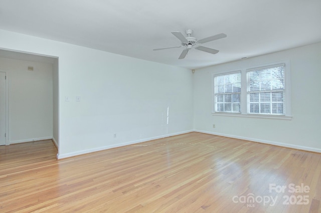 empty room featuring baseboards, light wood finished floors, and ceiling fan