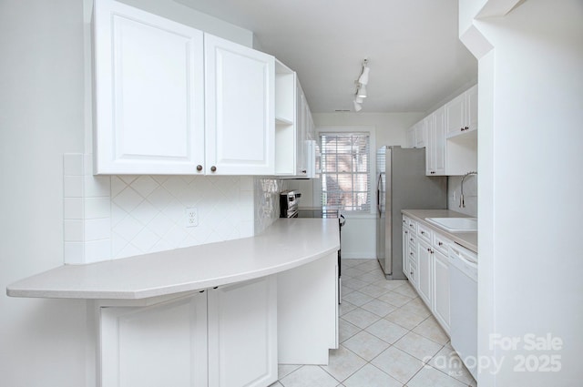 kitchen featuring white cabinetry, light tile patterned flooring, white dishwasher, and a sink