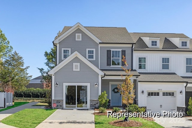 view of front of home featuring board and batten siding, stone siding, and a shingled roof