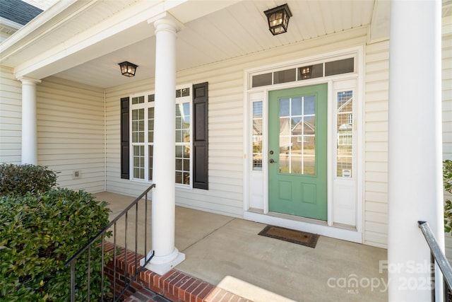 property entrance with covered porch and roof with shingles