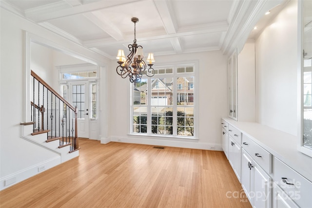 unfurnished dining area with beamed ceiling, coffered ceiling, stairway, and light wood-type flooring