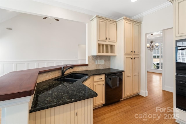 kitchen featuring a sink, black appliances, cream cabinetry, light wood-style floors, and crown molding