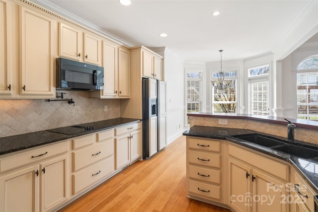 kitchen featuring crown molding, light wood-style floors, cream cabinetry, black appliances, and a sink