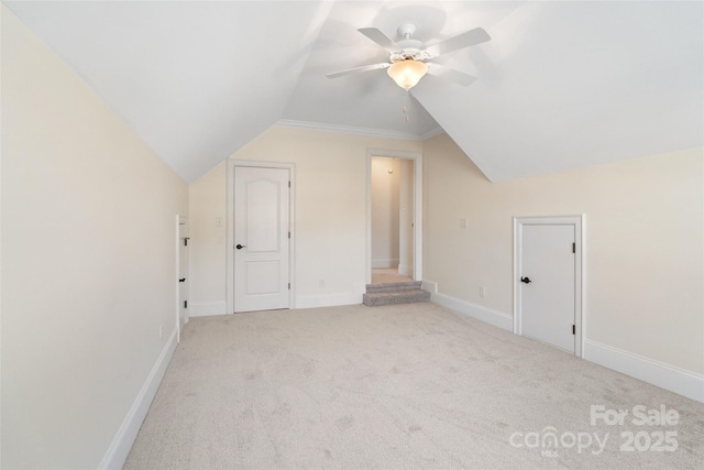 bonus room with light colored carpet, a ceiling fan, baseboards, and vaulted ceiling