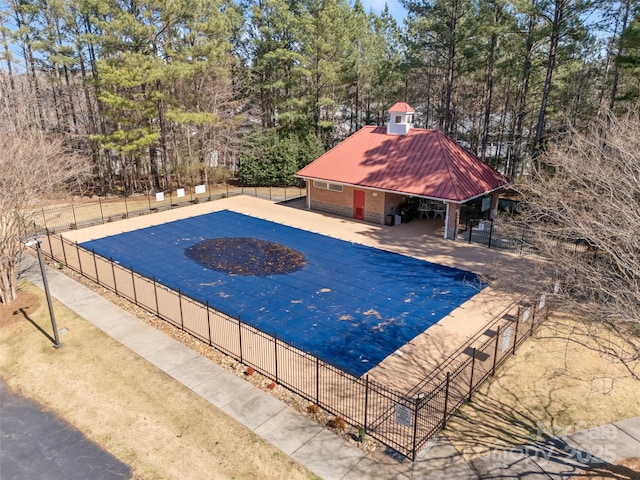 community pool with a patio and fence