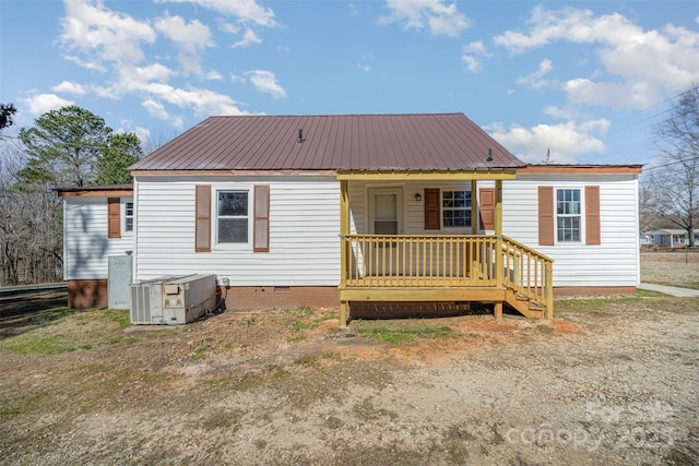 back of property with a porch, crawl space, central AC, and metal roof