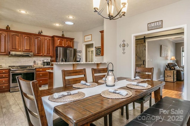 dining area with a chandelier, recessed lighting, a textured ceiling, and a barn door