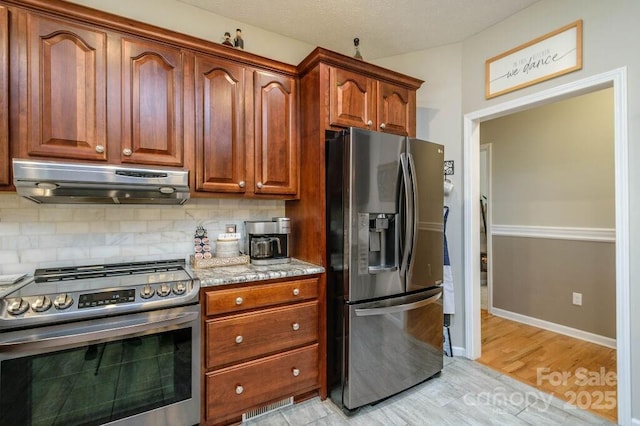 kitchen with light stone counters, baseboards, stainless steel appliances, decorative backsplash, and exhaust hood