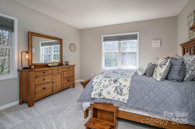 bedroom with baseboards and light colored carpet